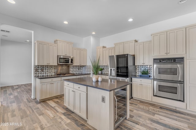 3806 E Taurus Pl, Chandler, AZ 85249 - kitchen with appliances with stainless steel finishes, cream cabinets, dark countertops, wine cooler, and recessed lighting