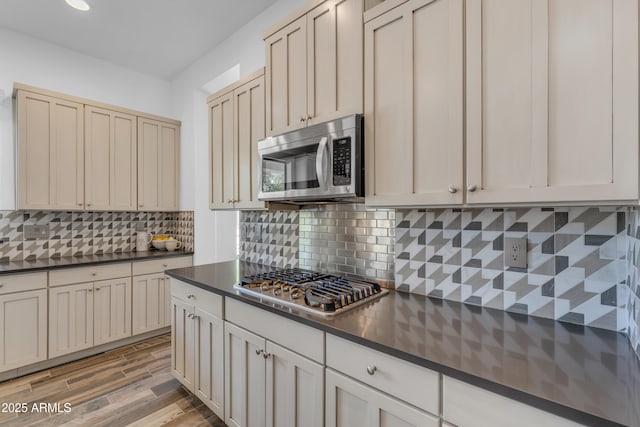 3806 E Taurus Pl, Chandler, AZ 85249 - kitchen with appliances with stainless steel finishes, dark countertops, backsplash, light wood-style flooring, and recessed lighting