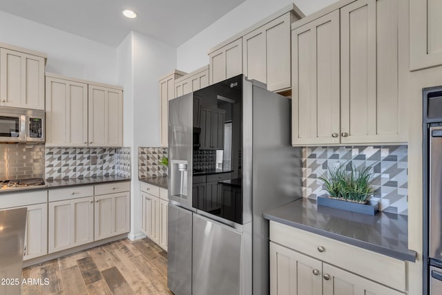 3806 E Taurus Pl, Chandler, AZ 85249 - kitchen with appliances with stainless steel finishes, decorative backsplash, dark countertops, light wood-style floors, and recessed lighting