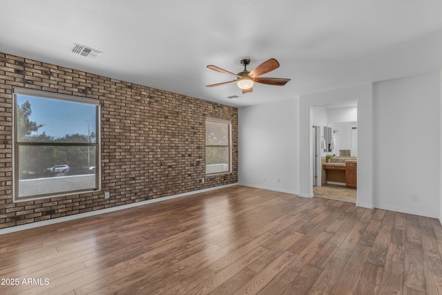 3806 E Taurus Pl, Chandler, AZ 85249 - unfurnished living room with brick wall, a ceiling fan, wood finished floors, and baseboards