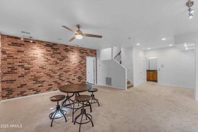 3806 E Taurus Pl, Chandler, AZ 85249 - unfurnished dining area featuring brick wall, ceiling fan, light colored carpet, baseboards, and stairway