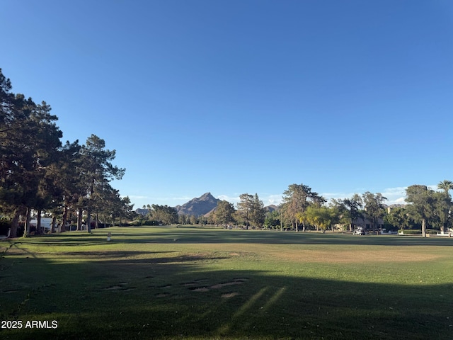 surrounding community with a yard and a mountain view