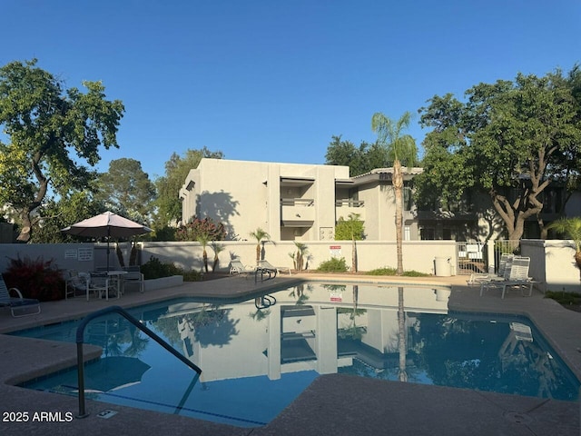 pool with fence and a patio area