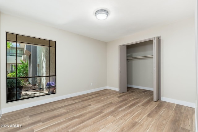 5221 N 24th St Unit 103, Phoenix, AZ 85016 - unfurnished bedroom featuring light wood-style flooring, baseboards, and a closet