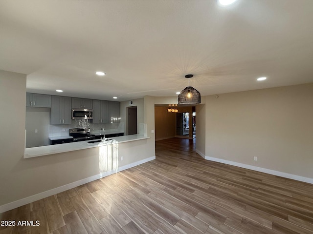 kitchen with gray cabinetry, light countertops, stainless steel appliances, and recessed lighting