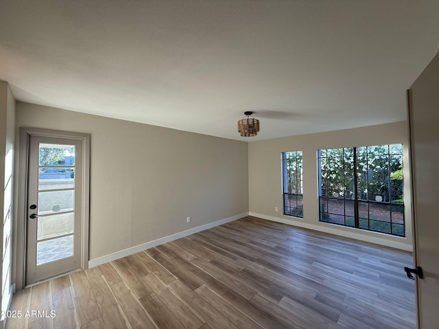 spare room featuring baseboards and wood finished floors