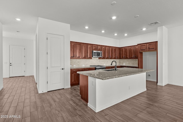 12308 W Parkway Ln, Avondale, AZ 85323 - kitchen featuring stainless steel appliances, a sink, wood finished floors, backsplash, and recessed lighting