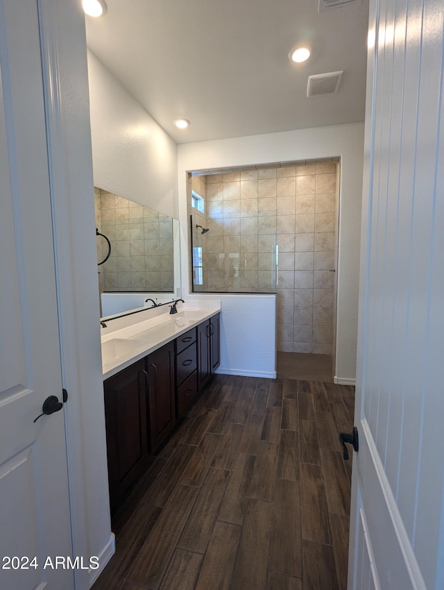 bathroom featuring walk in shower, vanity, hardwood / wood-style flooring, and tile walls