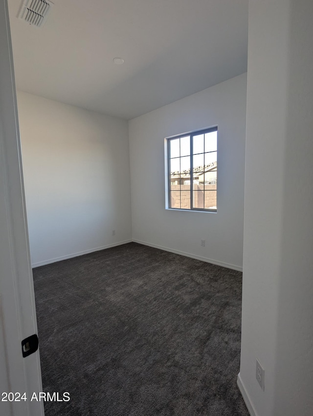 empty room featuring dark colored carpet