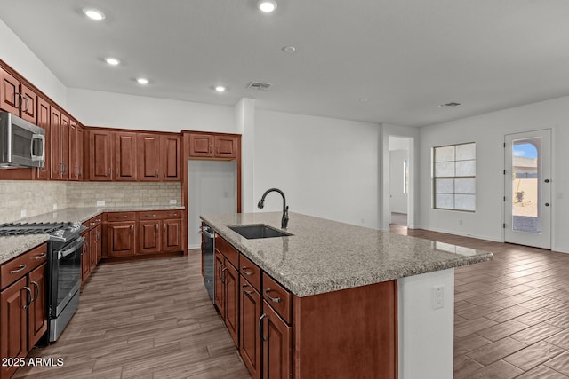 12308 W Parkway Ln, Avondale, AZ 85323 - kitchen featuring stainless steel appliances, a sink, wood finished floors, backsplash, and recessed lighting