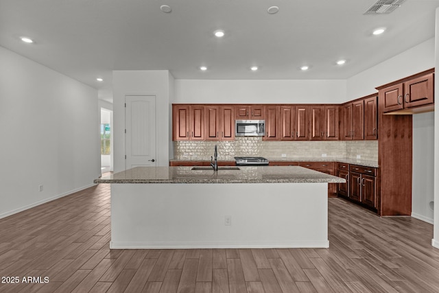 12308 W Parkway Ln, Avondale, AZ 85323 - kitchen featuring appliances with stainless steel finishes, a sink, an island with sink, wood finished floors, and recessed lighting