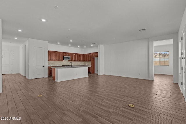 12308 W Parkway Ln, Avondale, AZ 85323 - kitchen with stainless steel microwave, open floor plan, recessed lighting, a sink, and tasteful backsplash