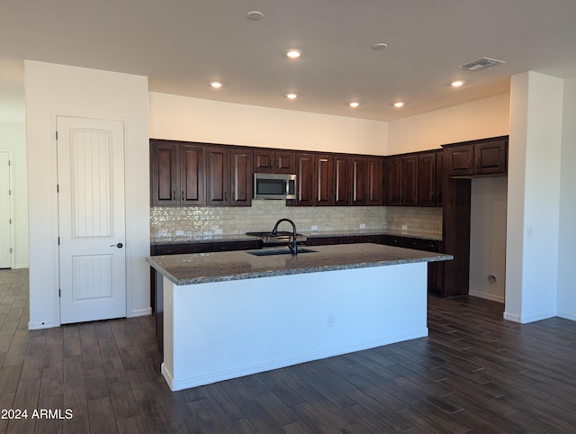 kitchen featuring dark hardwood / wood-style flooring, sink, and an island with sink