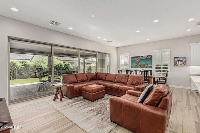 living room with recessed lighting, light wood finished floors, and visible vents