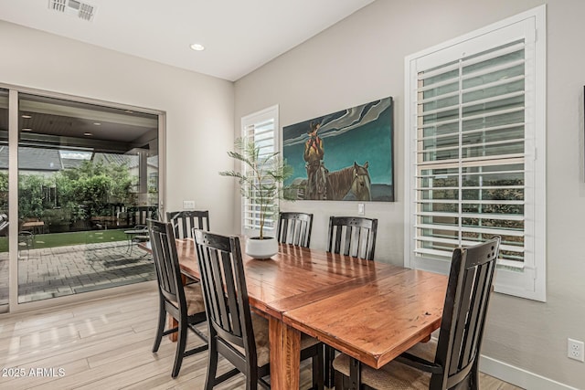 dining area featuring baseboards, visible vents, and light wood-type flooring