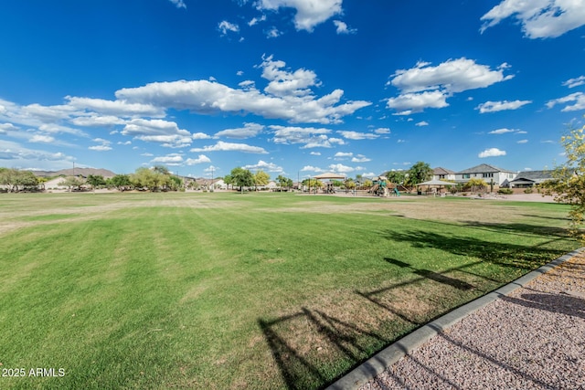 view of home's community with a yard, a residential view, and playground community