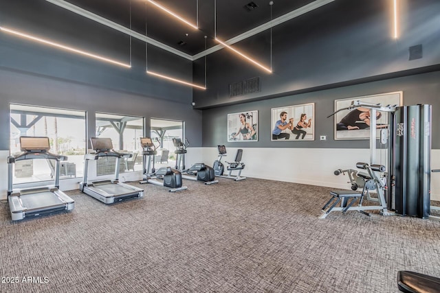gym featuring carpet floors, a high ceiling, and visible vents
