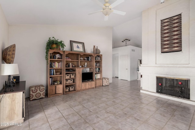 living area featuring a fireplace, a ceiling fan, and vaulted ceiling