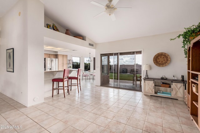 interior space featuring high vaulted ceiling, light tile patterned floors, visible vents, and ceiling fan