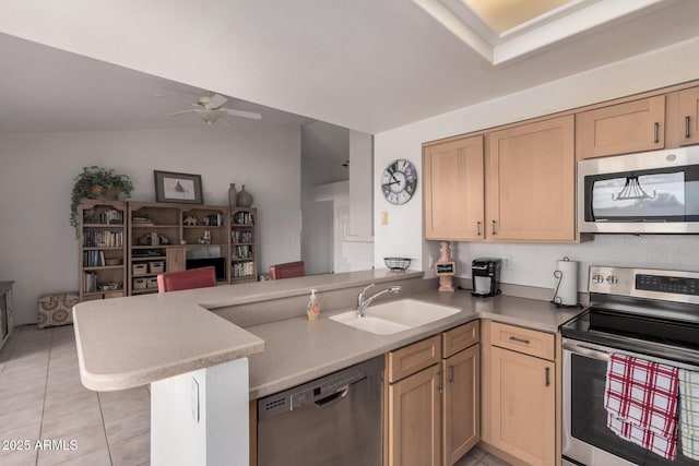 kitchen featuring a ceiling fan, a peninsula, a sink, appliances with stainless steel finishes, and open floor plan