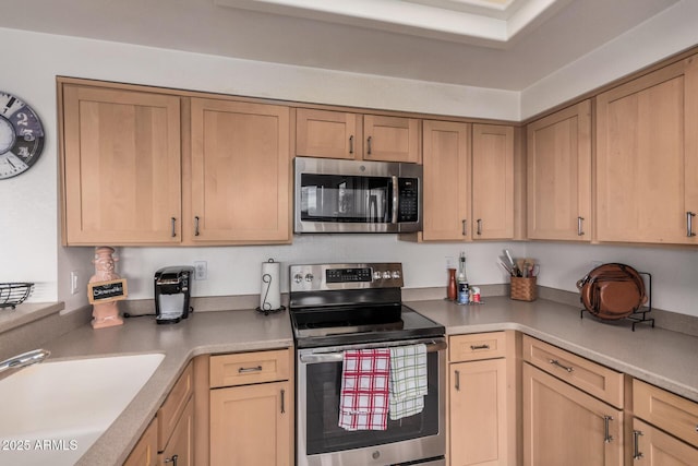 kitchen featuring a sink, light countertops, light brown cabinets, and stainless steel appliances