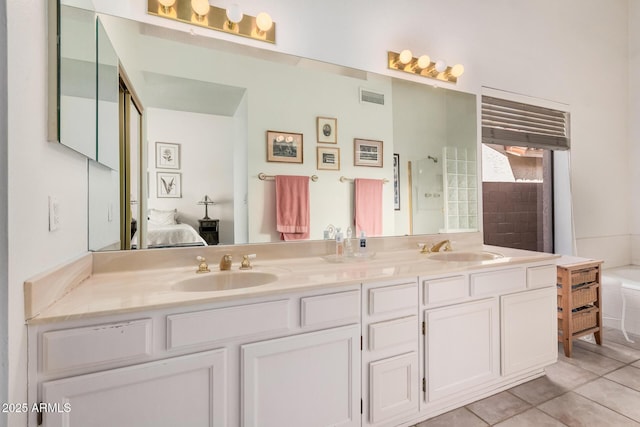 full bath with tile patterned flooring, connected bathroom, visible vents, and a sink