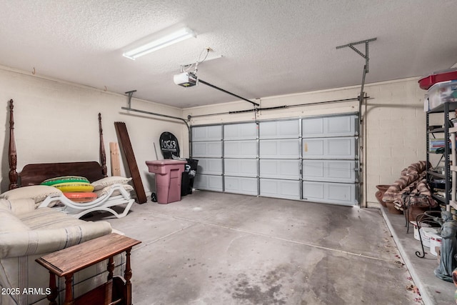 garage featuring concrete block wall and a garage door opener