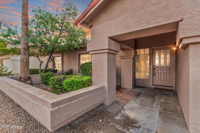 exterior entry at dusk with stucco siding