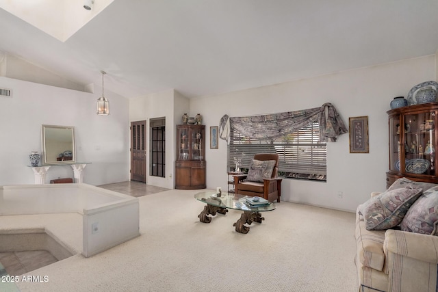 carpeted living area with visible vents and vaulted ceiling