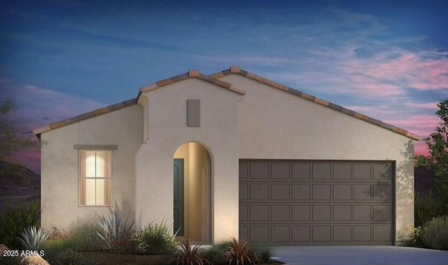 view of front of house featuring a garage, concrete driveway, and stucco siding