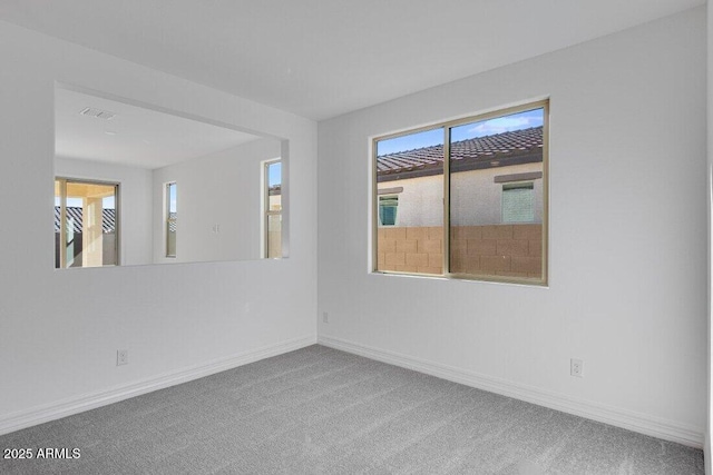 carpeted spare room featuring visible vents and baseboards