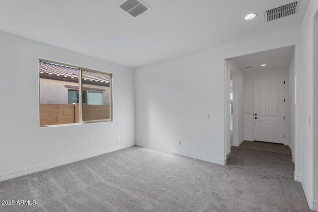 spare room featuring carpet, visible vents, and baseboards