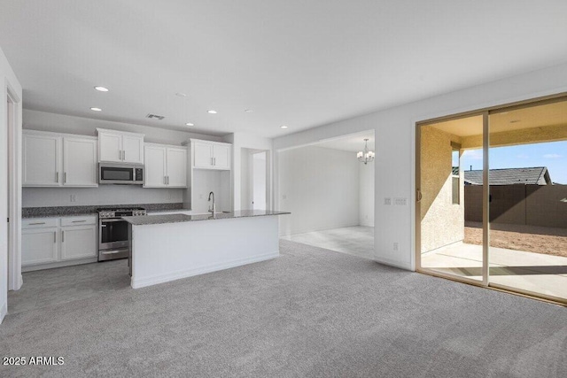 kitchen featuring a center island with sink, visible vents, white cabinets, appliances with stainless steel finishes, and recessed lighting