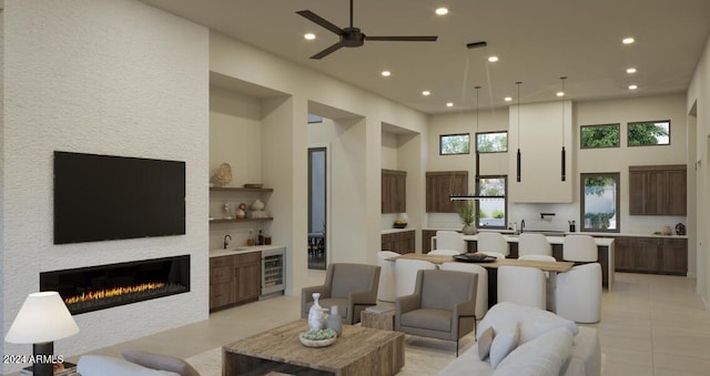 living room with light tile patterned floors, wine cooler, ceiling fan, a towering ceiling, and sink