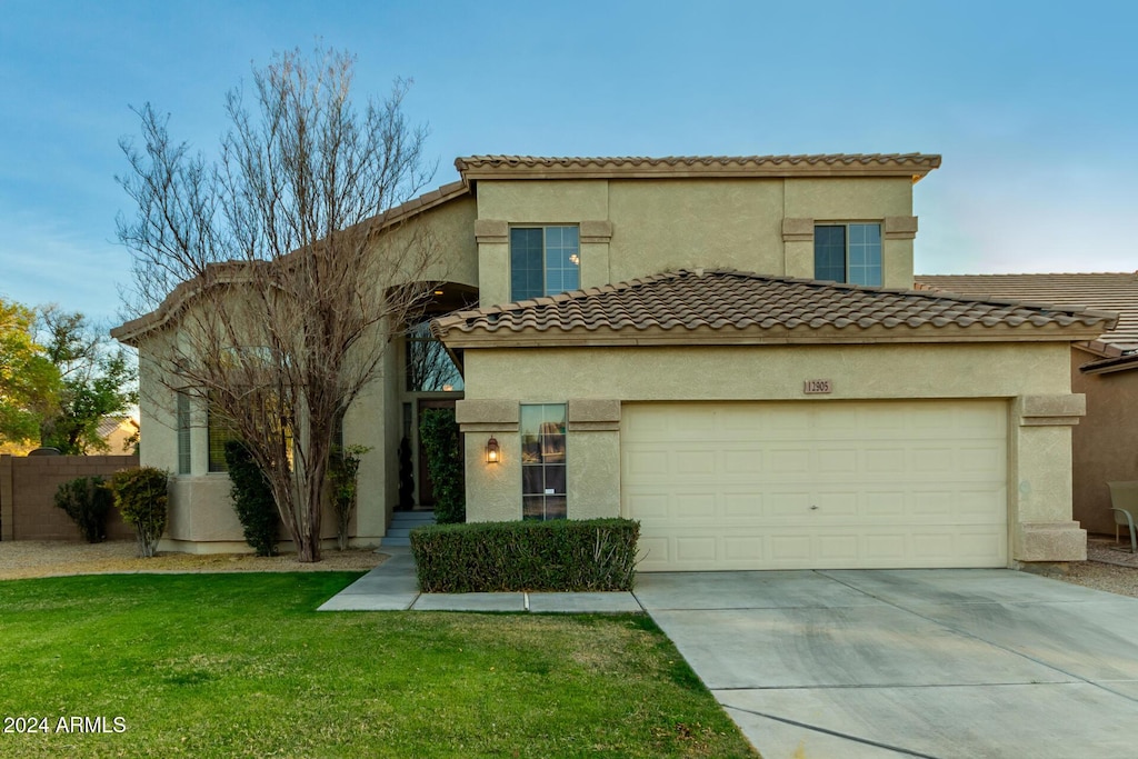 mediterranean / spanish-style home featuring a garage and a front yard