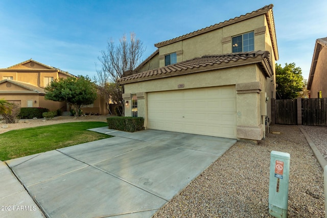 mediterranean / spanish house featuring a garage and a front yard