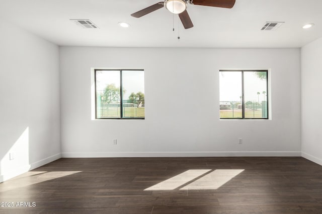 unfurnished room with wood finished floors, visible vents, and a healthy amount of sunlight