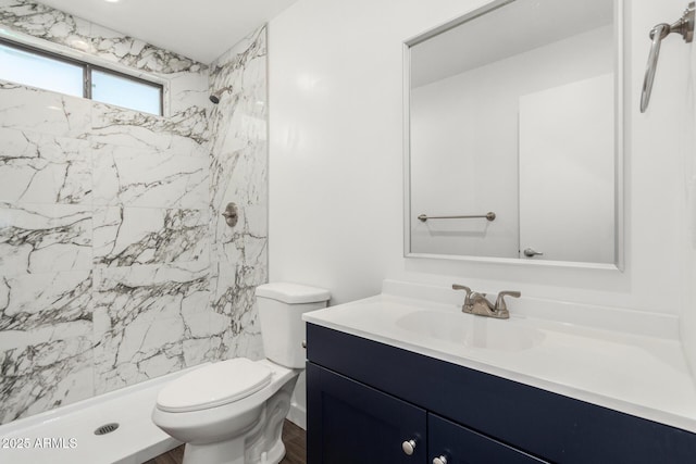 bathroom featuring toilet, a stall shower, and vanity