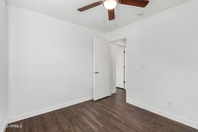 empty room featuring dark wood finished floors, baseboards, and ceiling fan