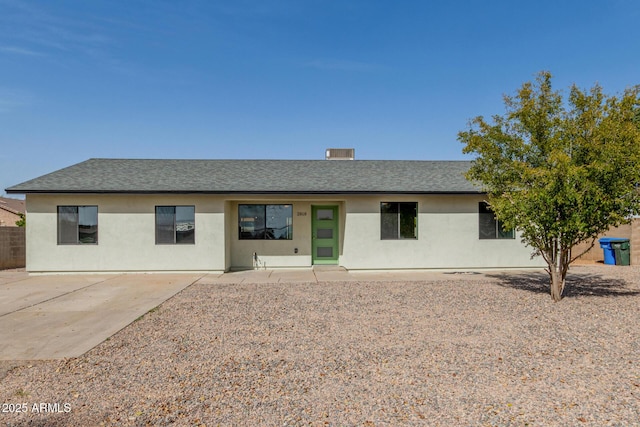 view of front of property featuring roof with shingles, a patio, and stucco siding