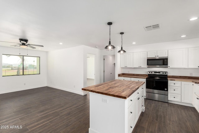 kitchen featuring dark wood-style floors, stainless steel appliances, recessed lighting, visible vents, and wooden counters