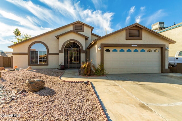 view of front of property featuring a garage and cooling unit