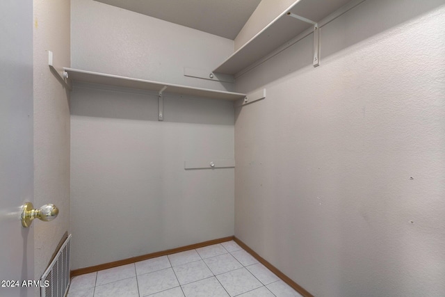 spacious closet featuring radiator and light tile patterned flooring