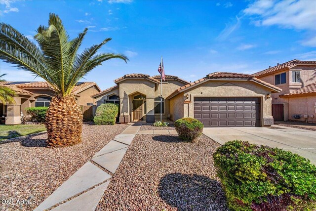 mediterranean / spanish house with concrete driveway, a tiled roof, a garage, and stucco siding