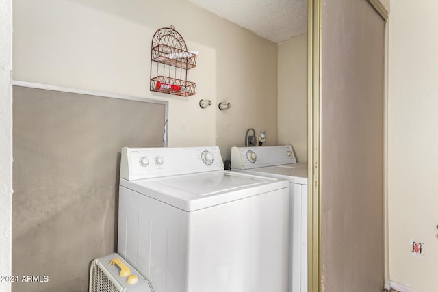 washroom featuring separate washer and dryer and a textured ceiling