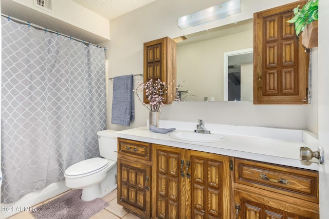 bathroom featuring tile patterned flooring, a textured ceiling, vanity, and toilet