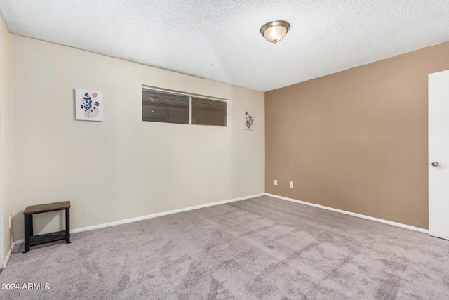 carpeted spare room with a textured ceiling