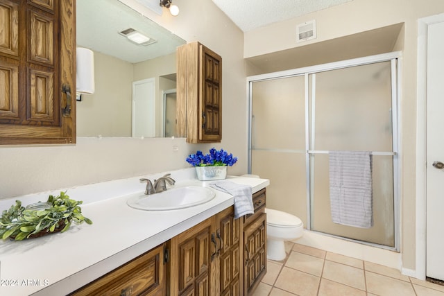 bathroom featuring tile patterned floors, vanity, a textured ceiling, and walk in shower