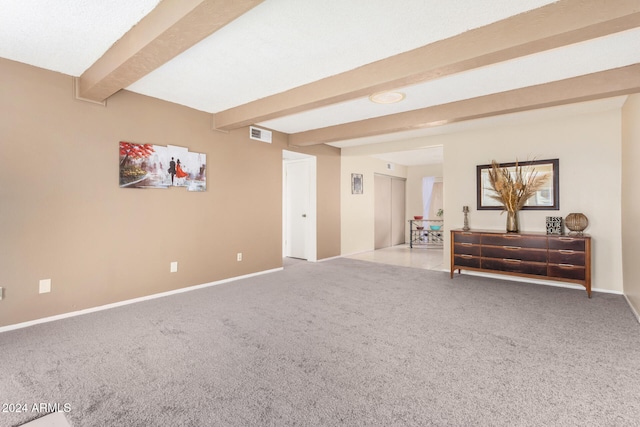 interior space featuring beamed ceiling and light colored carpet