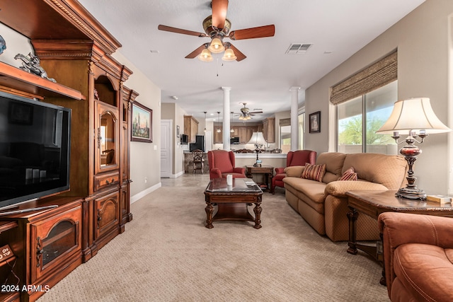 carpeted living room featuring decorative columns and ceiling fan